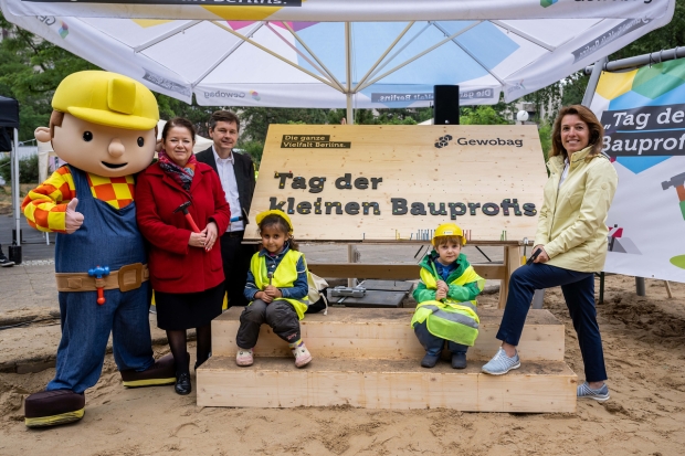 Sechs Personen vor einem Holzschild mit der Aufschrift 