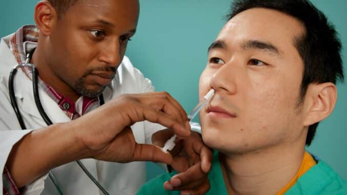 doctor suctioning on man's nose