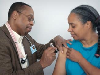 man doing syringe on woman wearing blue shirt