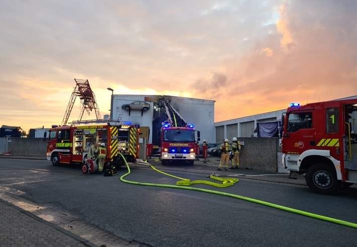 FW Lehrte: Feuer in Abschleppunternehmen: Sattelauflieger mit Elektrorollern sowie mehrere PKW brennen in Halle vollständig ab.