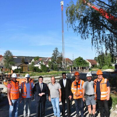 Im Austausch über den Fortschritt beim Neubau der Tauberbrücke Elpersheim: Oberbauleiter Nikos Asvestas und Bauleiter Jonas Irro (beide Firma Leonhard Weiß), Landrat Christoph Schauder, Ortsvorsteher Hans-Joachim Haas, Bürgermeister Nick Schuppert, der stellvertretende Straßenbauamtsleiter Christian Meißner, Polier Markus Rüdele (Leonhard Weiß) und der örtliche Bauüberwacher Reinhold Ernst vom Straßenbauamt.