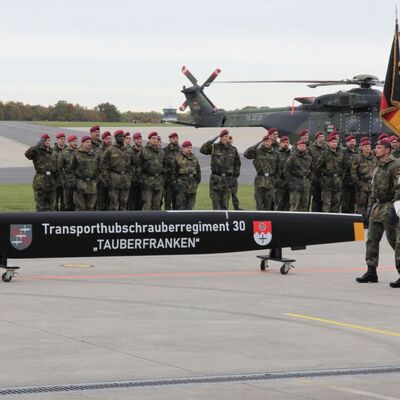 Die Truppenfahne schreitet an der Formation und dem Rotorblatt vorbei. Der neue Beiname "Tauberfranken" ziert das Rotorblatt.