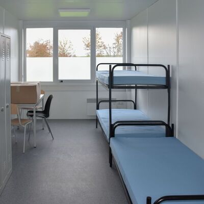 In jedem Schlafraum in der neuen Gemeinschaftsunterkunft stehen jeweils drei Betten und Spinde, ein Tisch mit Stühlen sowie ein Kühlschrank zur Verfügung.