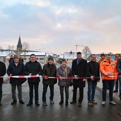 Das Absperrband auf der neuen Tauberbrücke durchschnitten (von links) Christian Meißner (stellvertretender Leiter Straßenbauamt), Ortsvorsteher Hans-Joachim Haas, der älteste Einwohner Elpersheims, Harry Welm, Landrat Christoph Schauder, die Elpersheimer Bürger Helmut Lang und Ruth Stirnkorb, Bürgermeister Nick Schuppert, vom Bauunternehmen Leonhard Weiss Sascha Bißwanger, Philipp Wieland und Michael Hallmeyer sowie Straßenbauamtsleiter Markus Metz.