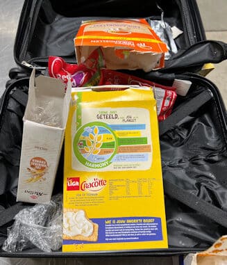 Offene Lebensmittelverpackungen in Koffer
