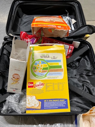 Offene Lebensmittelverpackungen in Koffer