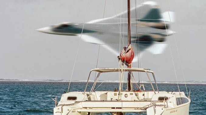 person in red shirt and white shorts sitting on white boat during daytime