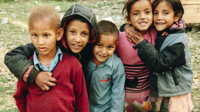 group of children standing on grass field during daytime