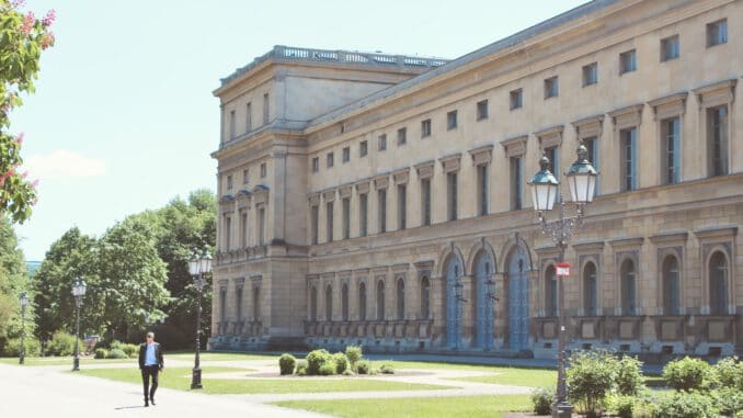 people walking on pathway near brown concrete building during daytime