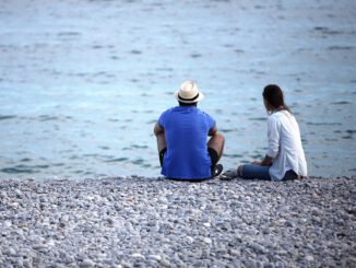 Mann und Frau sitzen am Strand, über dts Nachrichtenagentur