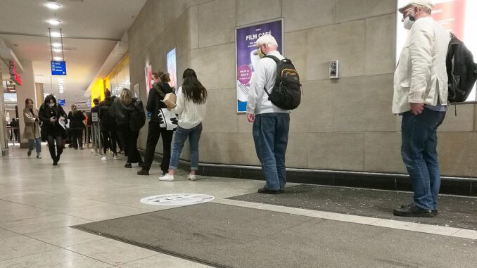 Menschen in einer Corona-Warteschlange, über dts Nachrichtenagentur