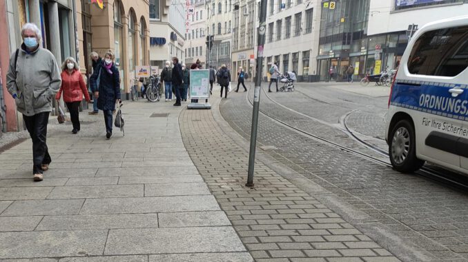 Menschen mit Maske in einer Innenstadt, über dts Nachrichtenagentur