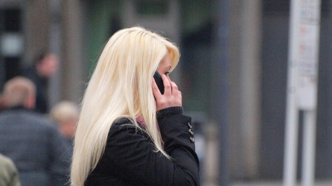 Blonde Frau mit Telefon, über dts Nachrichtenagentur