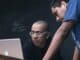 two men watching on silver MacBook
