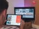 man browsing tablet sitting in front of TV