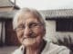 woman in gray sweater wearing black framed eyeglasses