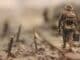 soldier walking on wooden pathway surrounded with barbwire selective focus photography