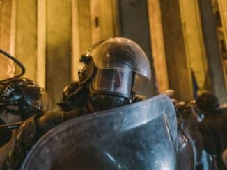 man wearing helmet and holding shield