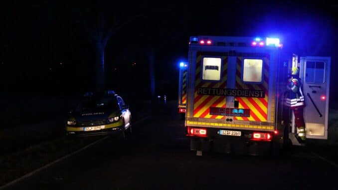 an ambulance and a police car on a road at night