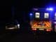 an ambulance and a police car on a road at night